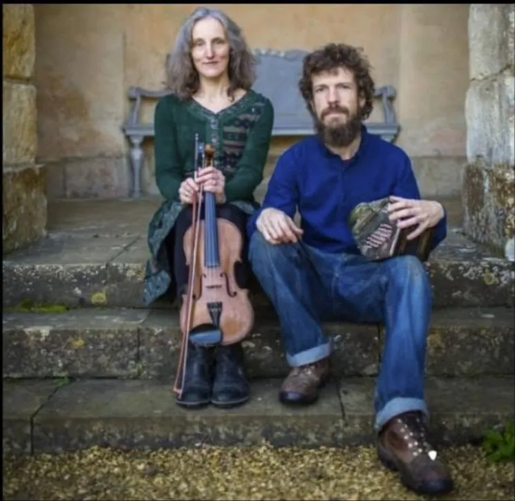 Jim and Jane sit on steps with their instruments